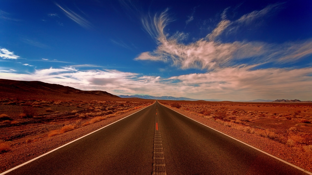 Long road in a desert and blue skies