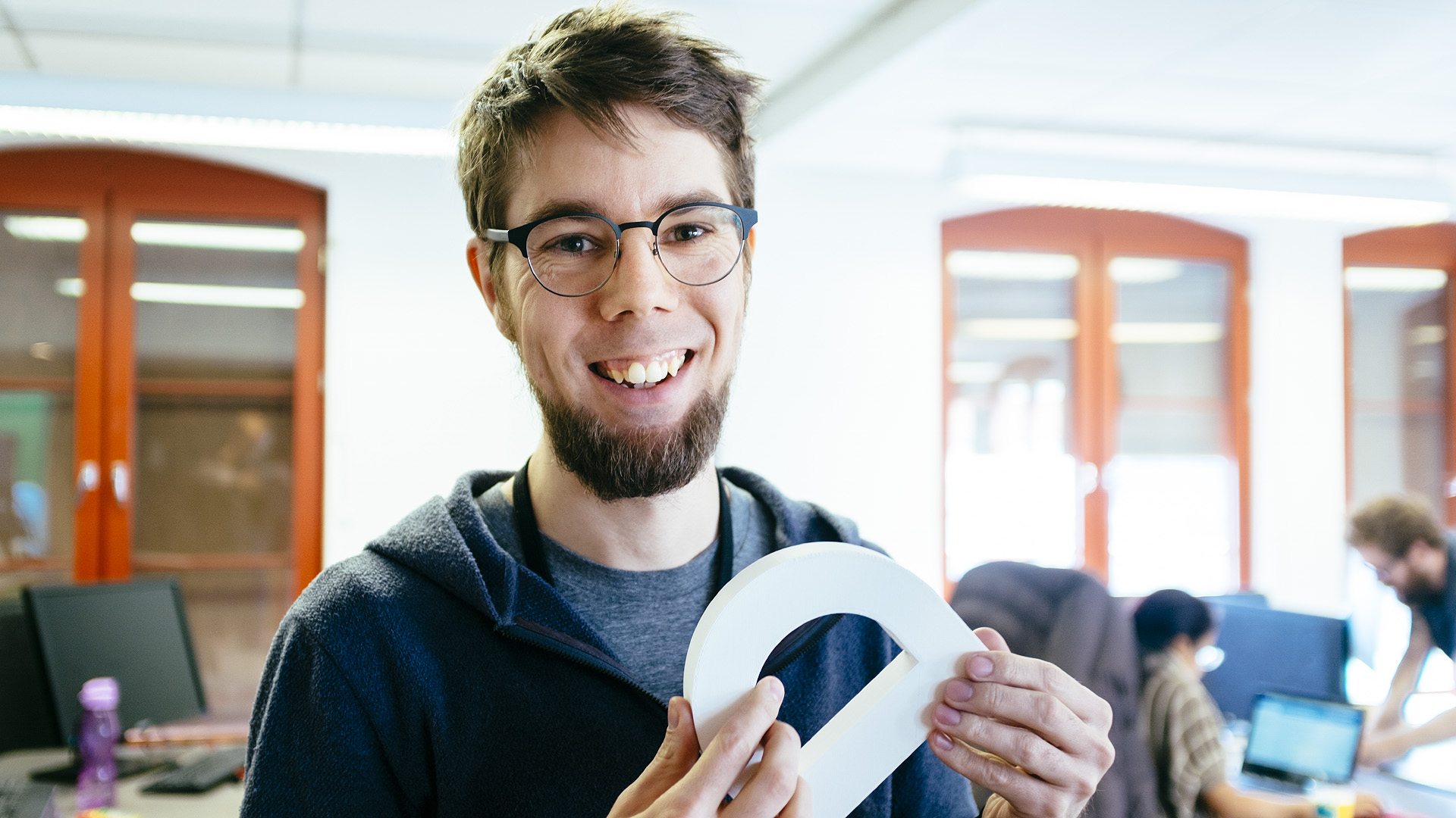 Designer Atle Mo standing in the Vivaldi Oslo office, holding a large letter D.