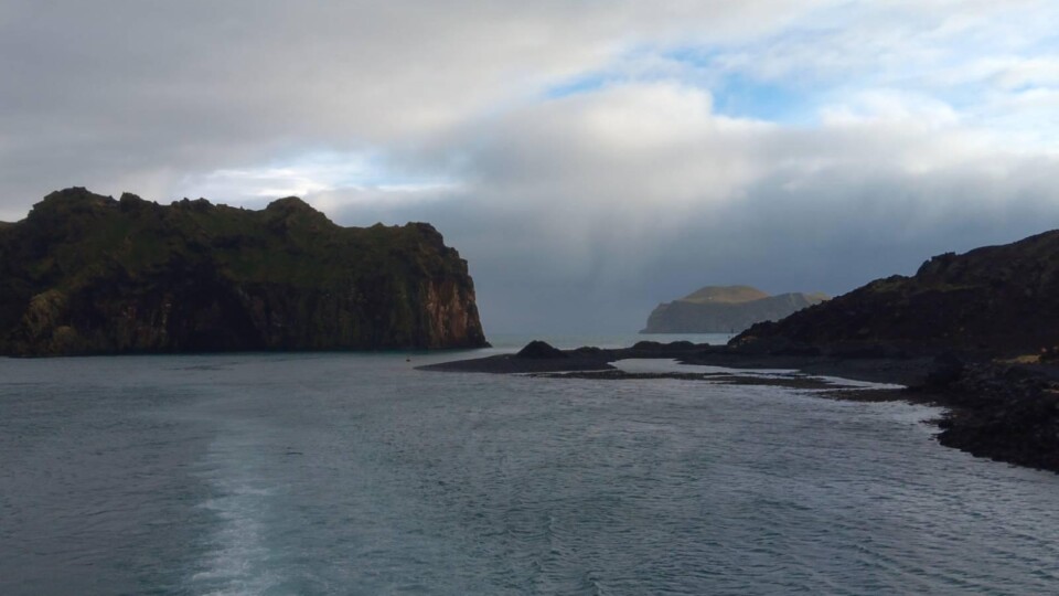 Rocky landscape sticking out of the water with cloud covered skies