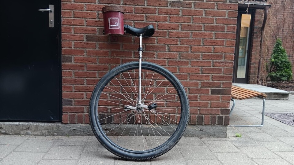 36 inch wheeled unicycle, leaning n a brick wall.