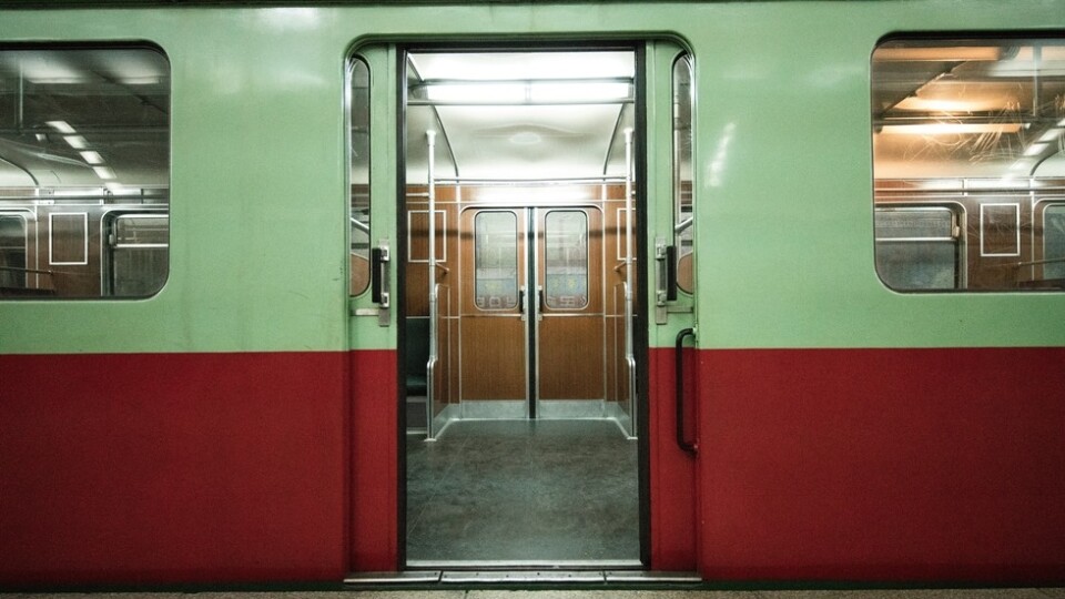 Empty mass rapid transit carriage, viewed from the side with the doors ajar.